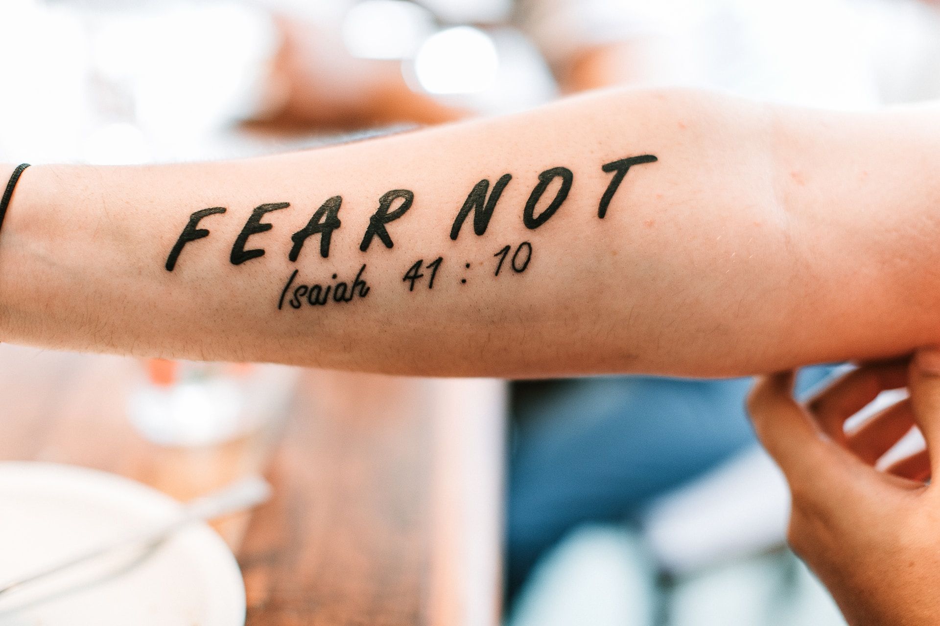 bras tatoué avec un verset biblique - Photo by James Coleman on https://unsplash.com/fr/photos/personne-avec-peur-pas-de-tatouage-sur-le-bras-m1lS3CwUOus