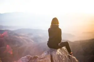 une personne assise au sommet d'une montagne contemple le panorama - Image par StockSnap de Pixabay 