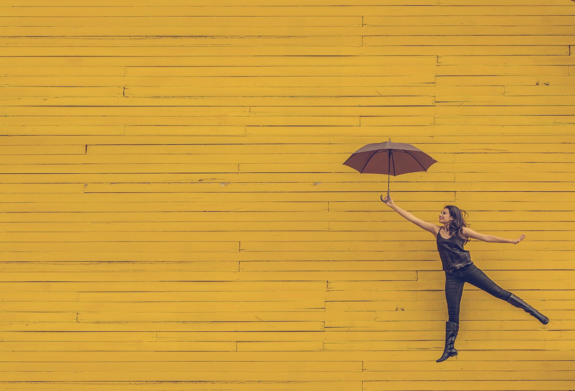 une femme tenant un parapluie semble s'envoller - Photo by Edu Lauton on https://unsplash.com/fr/photos/femme-tenant-un-parapluie-brun-TyQ-0lPp6e4