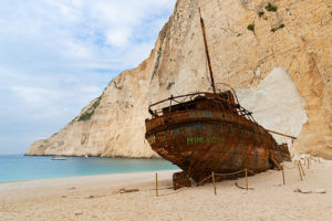 illustration : un bateau rouillé échoué sur une belle plage de sable - Image: 'Zakynthos Griechenland' by dronepicr  https://creativecommons.org/licenses/by/2.0/ http://www.flickr.com/photos/132646954@N02/44653188230