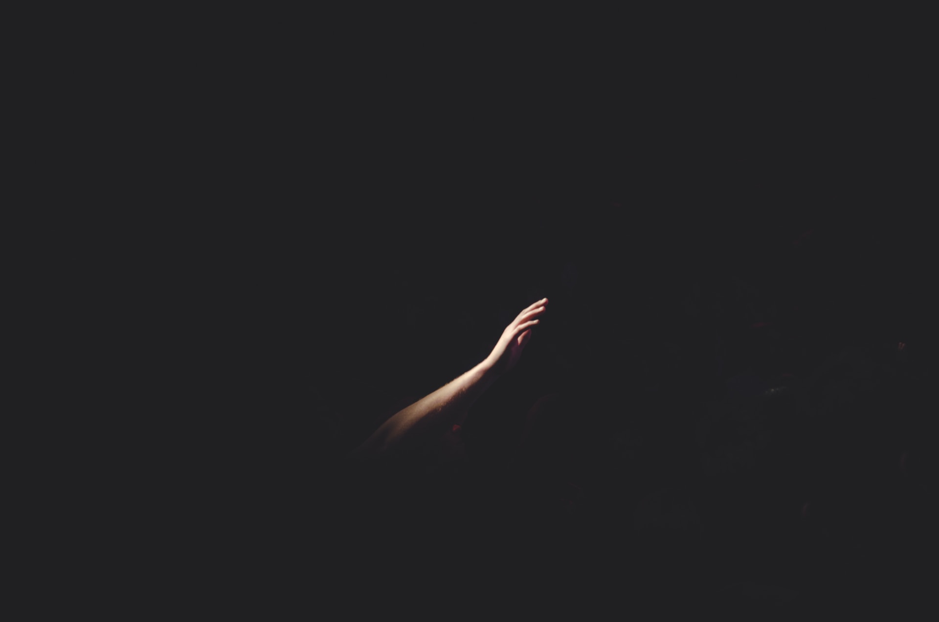 un bras tendu dans le noir - Photo by Cherry Laithang on https://unsplash.com/fr/photos/main-droite-de-lhomme-NmPpz1jA_JE