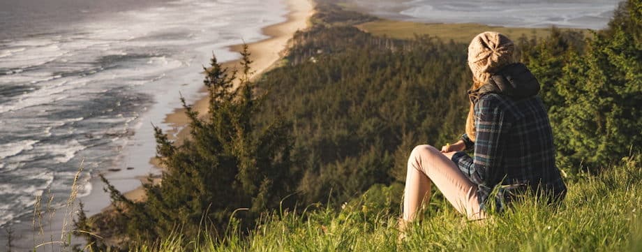 femme vue de dos, contemplant la mer depuis une montagne - Photo by Myles Tan on Unsplash
