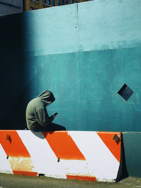 Illustration : homme en sweat à capuche regardant son téléphone - Photo by Jon Tyson on Unsplash