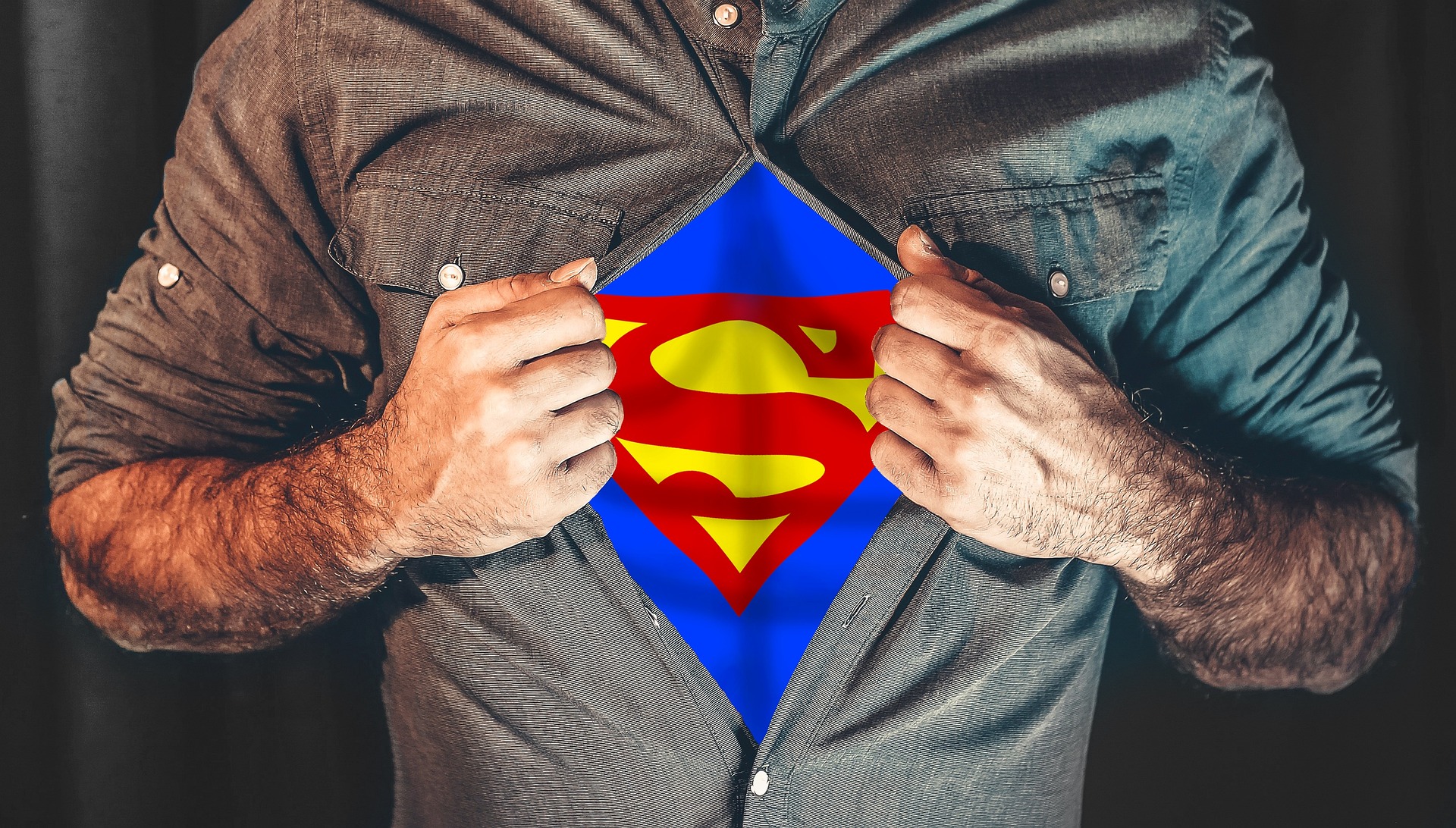 Un homme écarte sa chemise et on voit son costume de superhéros en dessous - Image par Elias de https://pixabay.com/fr/photos/super-h%C3%A9ros-la-chemise-d%C3%A9chirer-2503808/