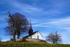 petite chapelle au sommet d'une colline se détachant sur le ciel bleu - Image par photosforyou de Pixabay 