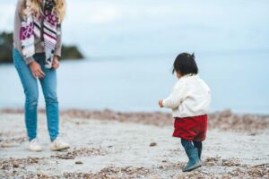 enfant qui fait ses premiers pas sous l'œil d'une maman - Photo de Guillaume de Germain sur https://unsplash.com/fr/photos/une-femme-et-un-petit-enfant-sur-une-plage-Yqtm6Fi8COM