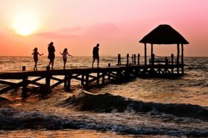 une famille avec enfants sur un ponton au coucher du soleil - Image par Jill Wellington de Pixabay 