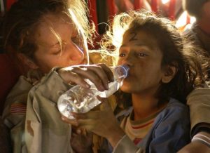 femme aidant une enfant réfugiée à boire - Image par skeeze de Pixabay 