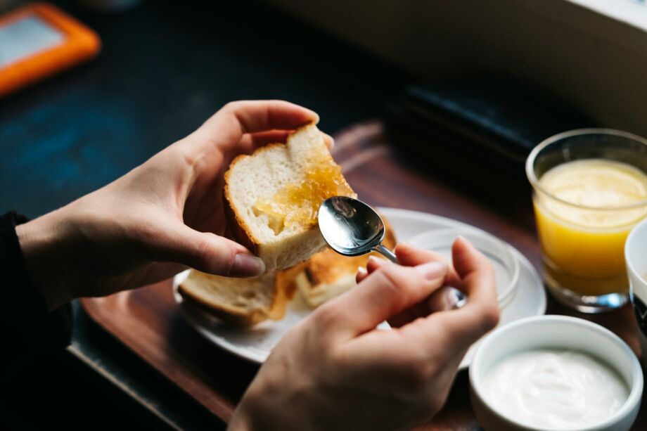 gros plan de mains préparant une tartine pour le petit déjeuner - Photo de Jonas Jacobssonsur https://unsplash.com/fr/photos/personne-etalant-de-la-confiture-sur-du-pain-4R0mm00gq6s