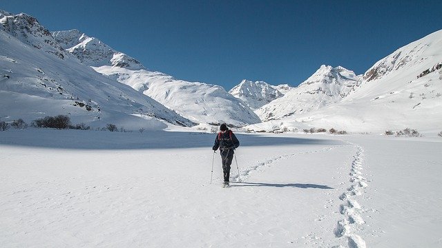 une personne seule marche dans la neige, à côté d
