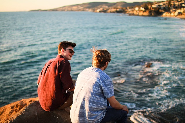 deux amis se parlent, assis sur le bord de la mer - Image par Free-Photos de Pixabay