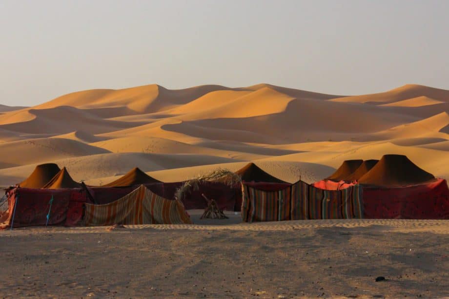 Village de tentes magnifiquement installé dans le désert de sable, au coucher du soleil - Photo de Maciej Cisowski sur https://unsplash.com/fr/photos/un-groupe-de-tentes-installees-dans-le-desert-bfBApvKdkS4