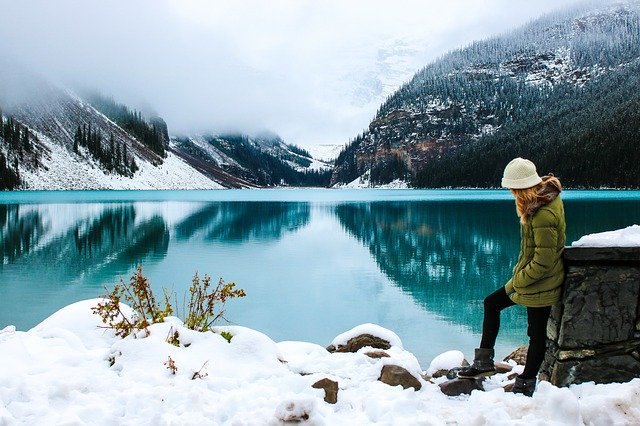 femme seule devant un lac de montagne, l'hiver - Image par Olya Adamovich de Pixabay