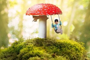 Composition montrant une petite fille faisant de la balançoire sous un champignon vénéneux - Image par DarkWorkX de Pixabay 