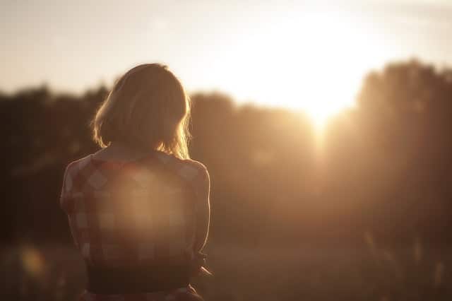 jeune femme regardant un coucher de soleil dans la campagne - Image par Free-Photos de Pixabay