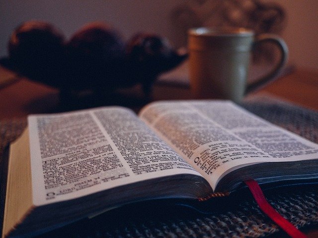 Une bible ouverte et une tasse de café dans la pénombre - Image par Free-Photos de Pixabay