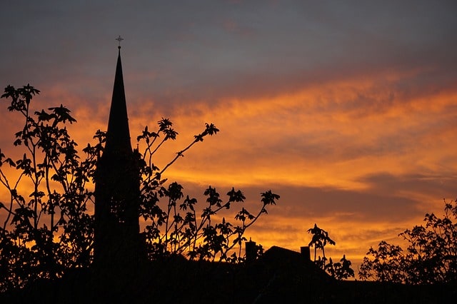 Un clocher d'église en Allemagne, se découpant sur un ciel d'aurore - Image par Haeslene de Pixabay