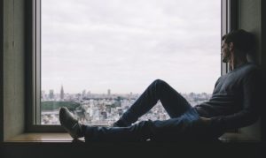 Un homme seul, assis à la fenêtre devant la ville - Image par Pexels de Pixabay 