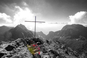 Une croix sur un sommet, avec des fleurs - photo Etienne Jeanneret