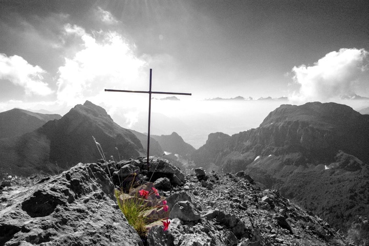 Une croix sur un sommet, avec des fleurs - photo Etienne Jeanneret