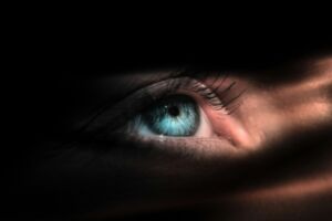 Un œil bleu éclairé dans l'ombre - Photo de Kevin Muellersur https://unsplash.com/fr/photos/persons-blue-eye-in-close-up-photography-ljz8-frLa9Q
