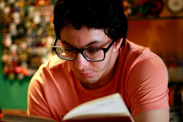 Jeune homme lisant un livre - Photo by Luiza Braun on Unsplash