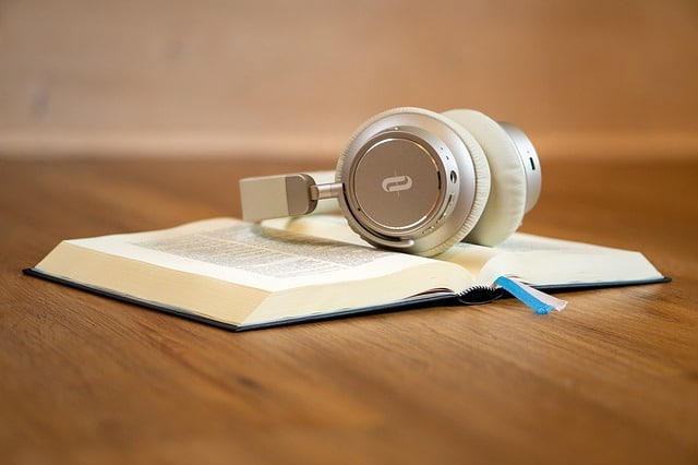 Une Bible ouverte avec des écouteurs posés dessus - Image par Kay Lenze de Pixabay