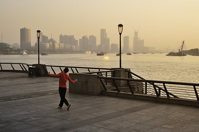Un homme danse sur un ponton face à une skyline - Image par zhugher de Pixabay