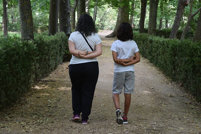 Une mère et son fils marchent sur un chemin, avec la même posture. Image par SeeMoon JaaMoon de Pixabay