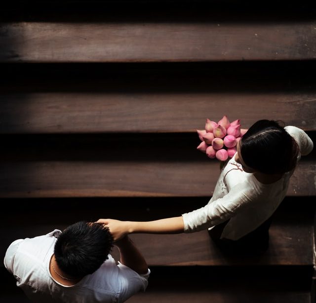 Une jeune femme et son fiancé vus de dessus, montant des marches d'escalier - Photo by Tron Le on Unsplash