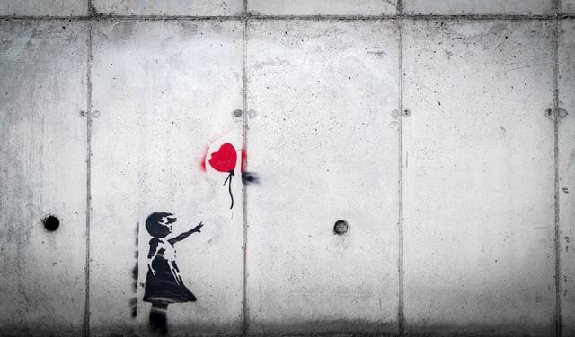 pochoir de Bansky représentant une petite fille lâchant un ballon en forme de cœur - Photo by Karim MANJRA on Unsplash