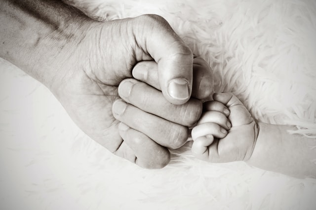 Une main d'homme et une main de bébé se rencontrent - Photo by Heike Mintel on Unsplash