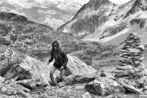 femme courant en montant dans une montagne - Photo noir et blanc by mauro paillex on Unsplash