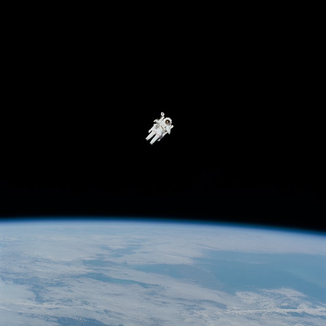 Un cosmonaute lors d'une sortie spatial, avec la terre en arrière-plan - Photo by NASA on Unsplash
