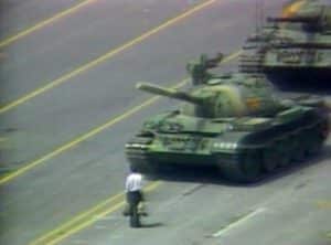 L'homme bloquant une ligne de chars sur la place Tiananmen - Flickr (CC BY 2.0) Brandon Carson Tiananmen Square From John Lennon's "Power to the People" video