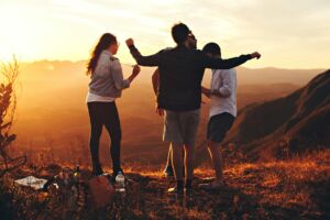 Un groupe d'amis en traint de parler joyeusement en montagne - Photo de Helena Lopes sur https://unsplash.com/fr/photos/quatre-personnes-debout-sur-le-bord-de-la-montagne-DkGIAjlIJu0