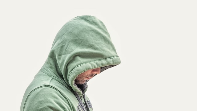 un homme avec le visage à demi caché dans sa capuche - Photo by LoboStudio Hamburg on Unsplash
