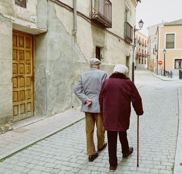 Un couple de personnes âgées marchent la main dans la main dans une ruelle - Photo by Wonsung Jang on Unsplash