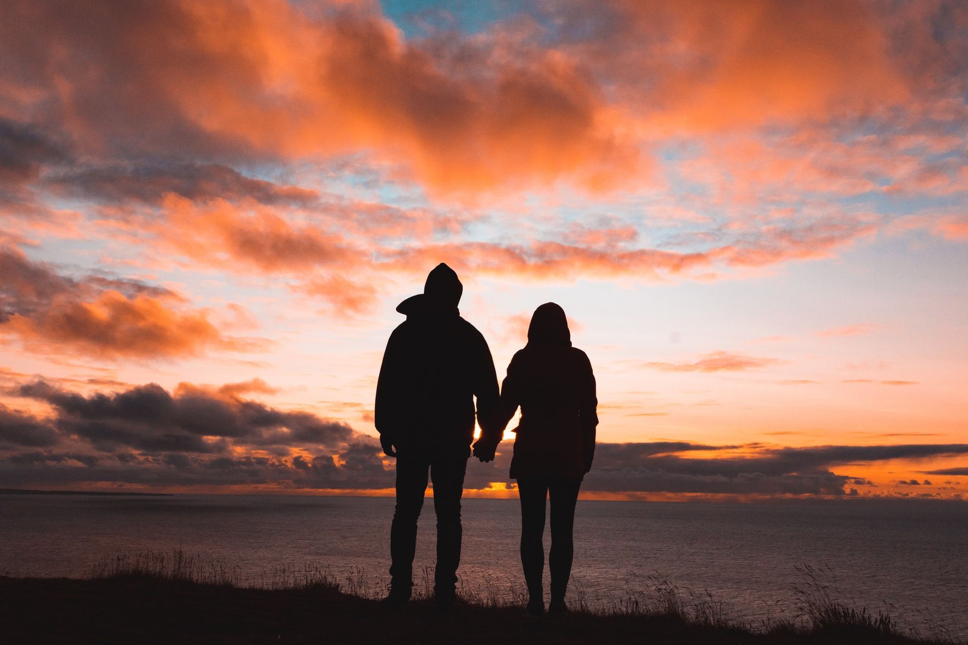 couple regardant l'horizon de la mer, l'horizon de la vie, au coucher de soleil ou au lever de soleil ? Photo by Alex Iby on Unsplash