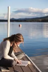 jeune femme lisant la Bible sur un ponton - Bethany Laird