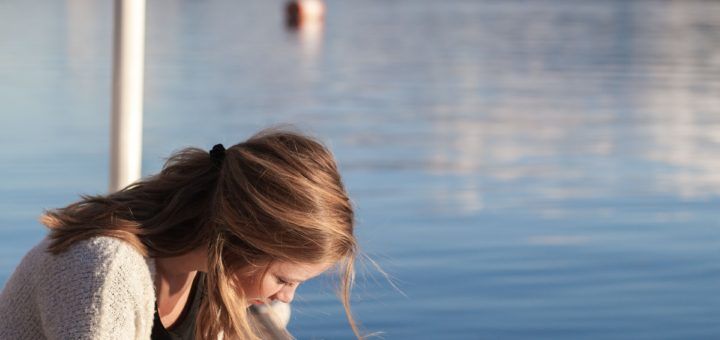jeune femme lisant la Bible sur un ponton - Bethany Laird