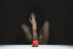 Gros plan sur une pomme avec une femme nue derrière se prenant la tête - Photo by engin akyurt on Unsplash