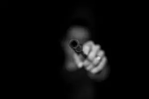 photo en noir et blanc montrant un pistolet braqué - Photo by Max Kleinen on Unsplash