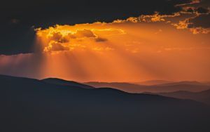 Soleil caché derrière des nuages, éclairant les montagnes - Photo by Marek Piwnicki on Unsplash