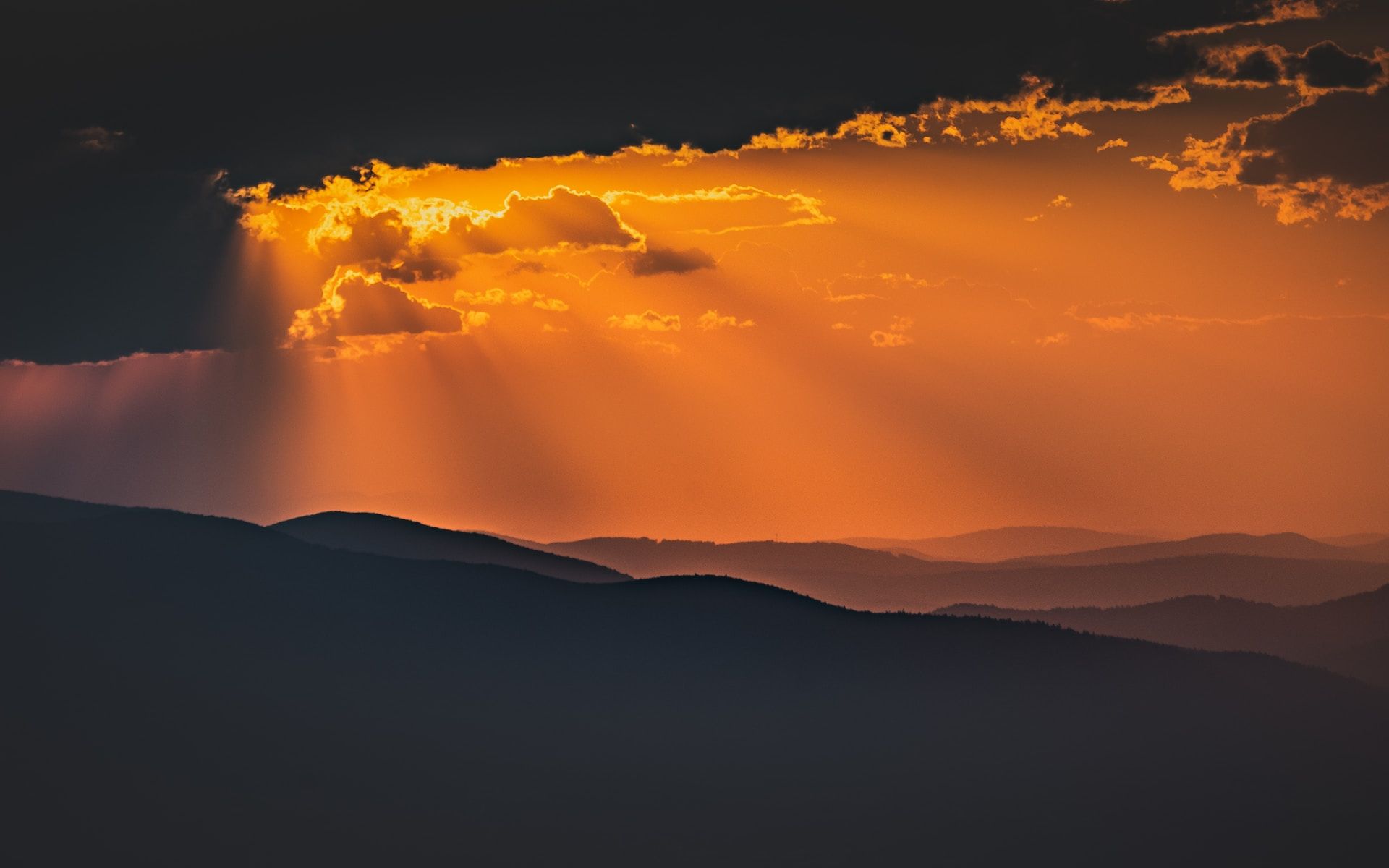 Soleil caché derrière des nuages, éclairant les montagnes - Photo by Marek Piwnicki on https://unsplash.com/fr/photos/silhouette-de-montagne-au-coucher-du-soleil-xjTGy_vS0eA