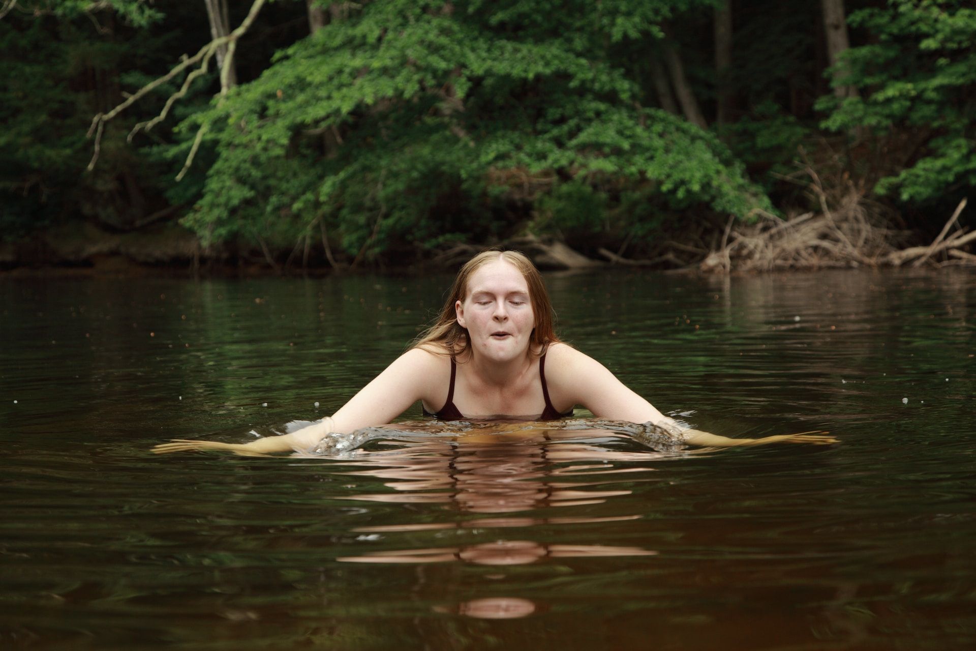 une jeune femme se met à l'eau dans un lac froid et s'apprête à nager - Photo by Tsunami Green on https://unsplash.com/fr/photos/femme-dans-le-plan-deau-pendant-la-journee-PYRxWCDvQtg