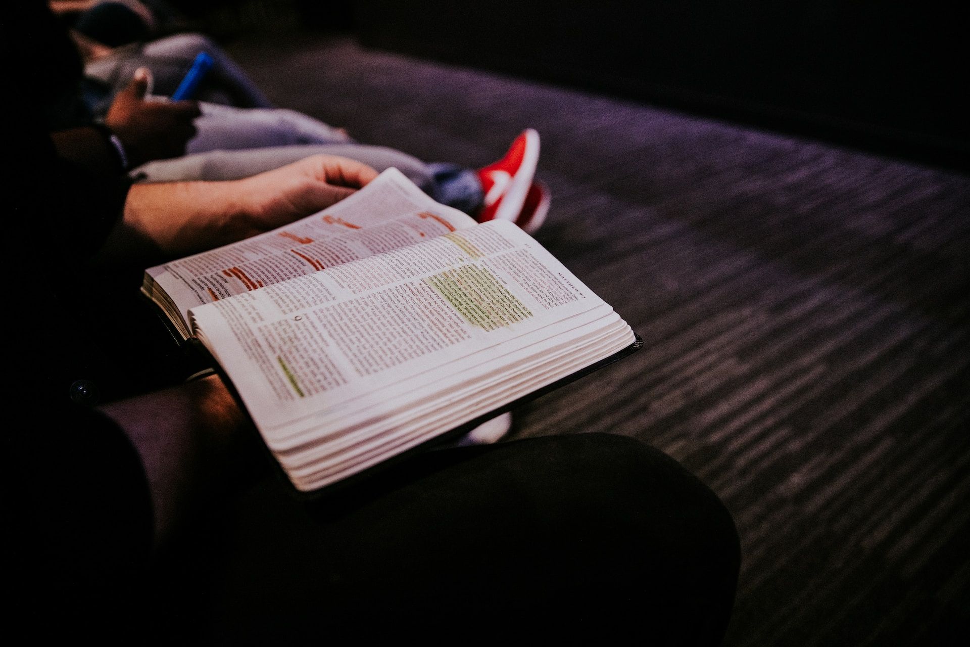 une personne tient sa Bible travaillée avec des couleurs pour souligner des versets - Photo by Hannah Busing on https://unsplash.com/fr/photos/personne-lisant-le-livre-G-_L3Eqkqmc
