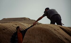 Une personne aide une autre personne tombée entre deux rochers à s'en sortir - Photo de joan m sur https://unsplash.com/fr/photos/un-homme-tend-la-main-a-un-autre-homme-au-sommet-dun-rocher-JYfLlOKRMaE