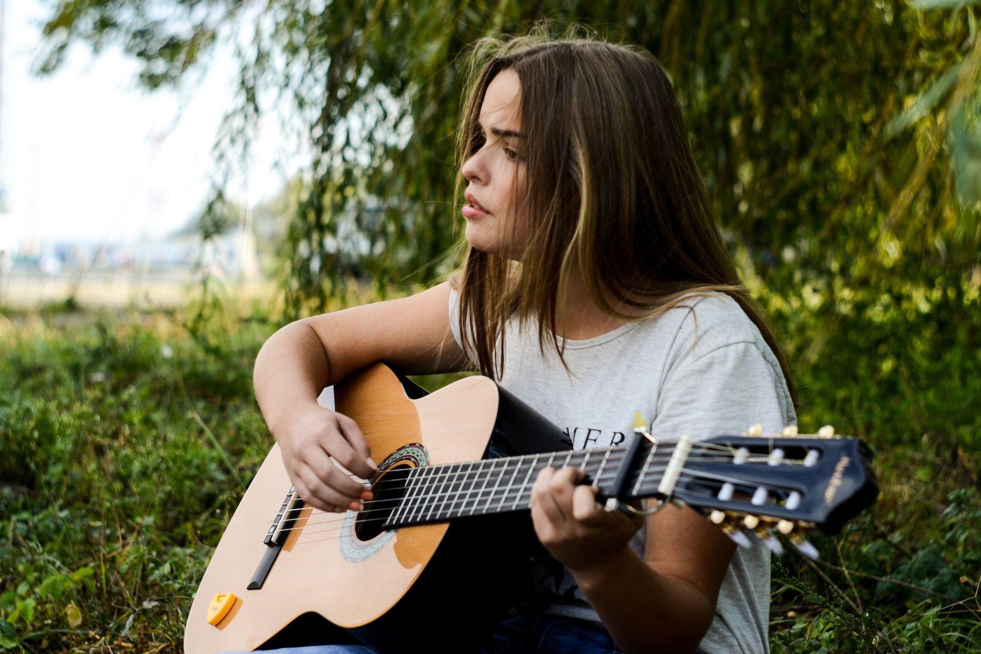 jeune femme chantant avec une guitare dans la nature - Photo by Mariana Vusiatytska on https://unsplash.com/fr/photos/femme-jouant-a-gitar-1PlJFiOyacw