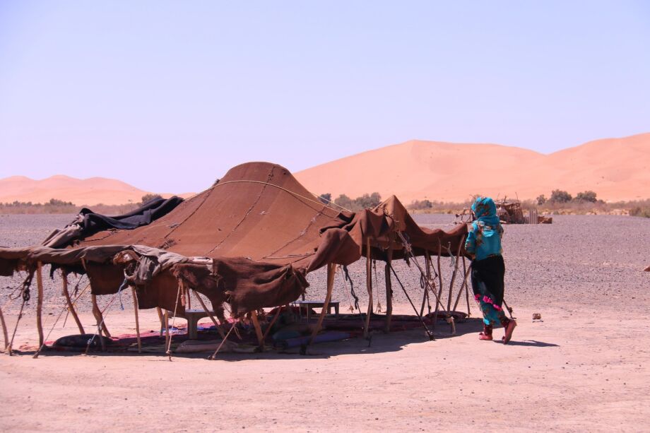 Une tente de bédouin dans le désert avec une femme qui remonte les bords de la tante - Image by Tania Dimas from https://pixabay.com/photos/trip-sand-desert-remote-control-3288047/